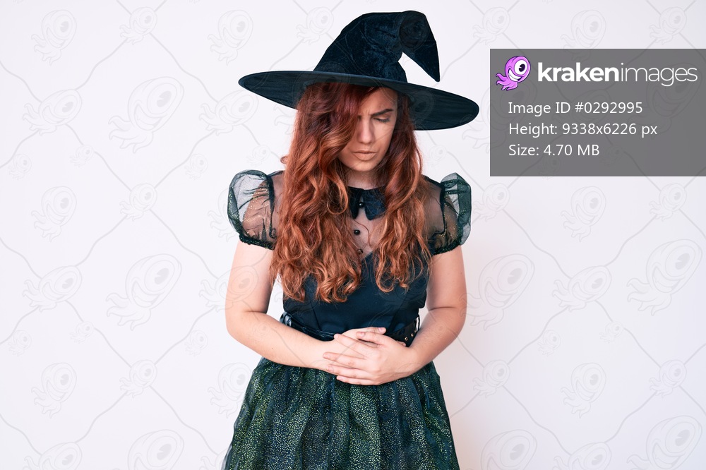 Young beautiful woman wearing witch halloween costume with hand on stomach because indigestion, painful illness feeling unwell. ache concept. 