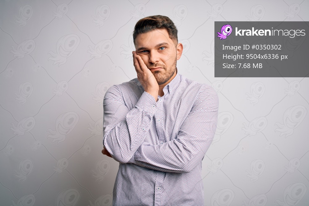 Young business man with blue eyes standing over isolated background thinking looking tired and bored with depression problems with crossed arms.