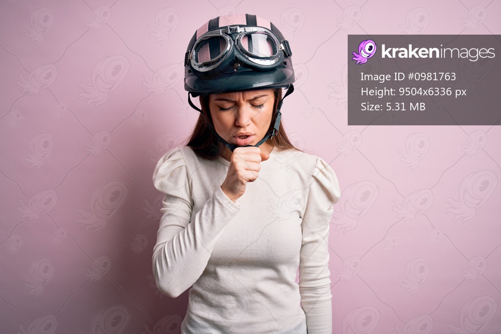 Young beautiful motorcyclist woman with blue eyes wearing moto helmet over pink background feeling unwell and coughing as symptom for cold or bronchitis. Health care concept.