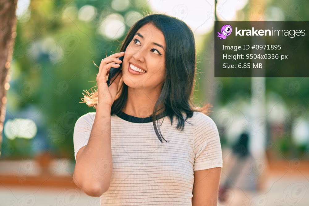 Young hispanic woman smiling happy talking on the smartphone at the city.