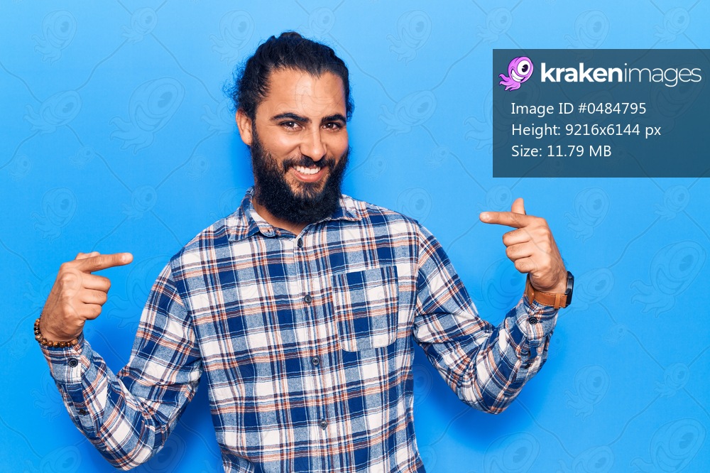 Young arab man wearing casual clothes looking confident with smile on face, pointing oneself with fingers proud and happy. 