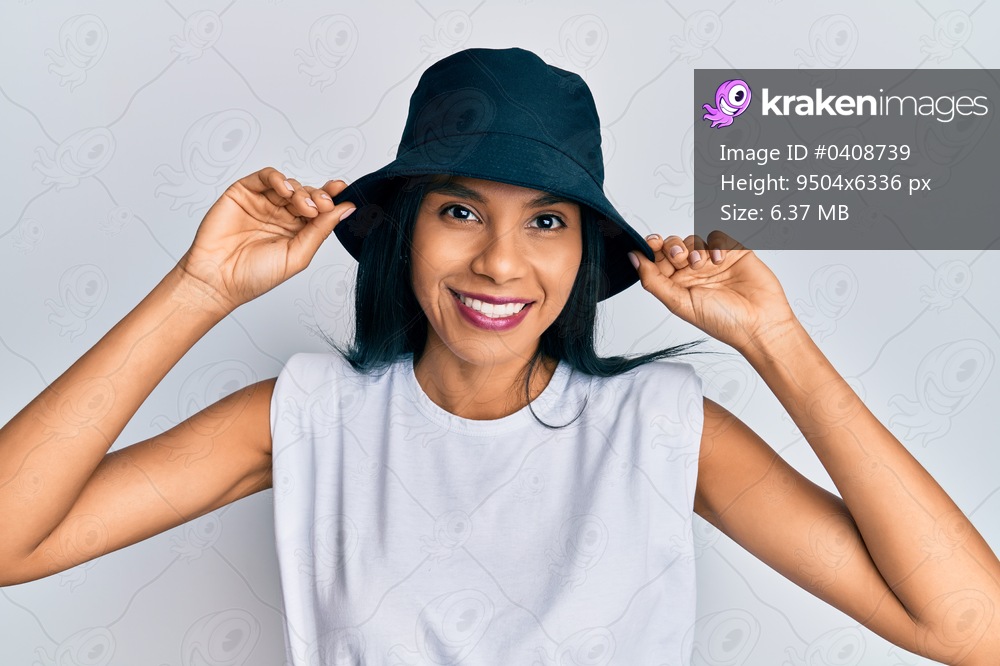 Young african american woman wearing fashion hat smiling with a happy and cool smile on face. showing teeth. 