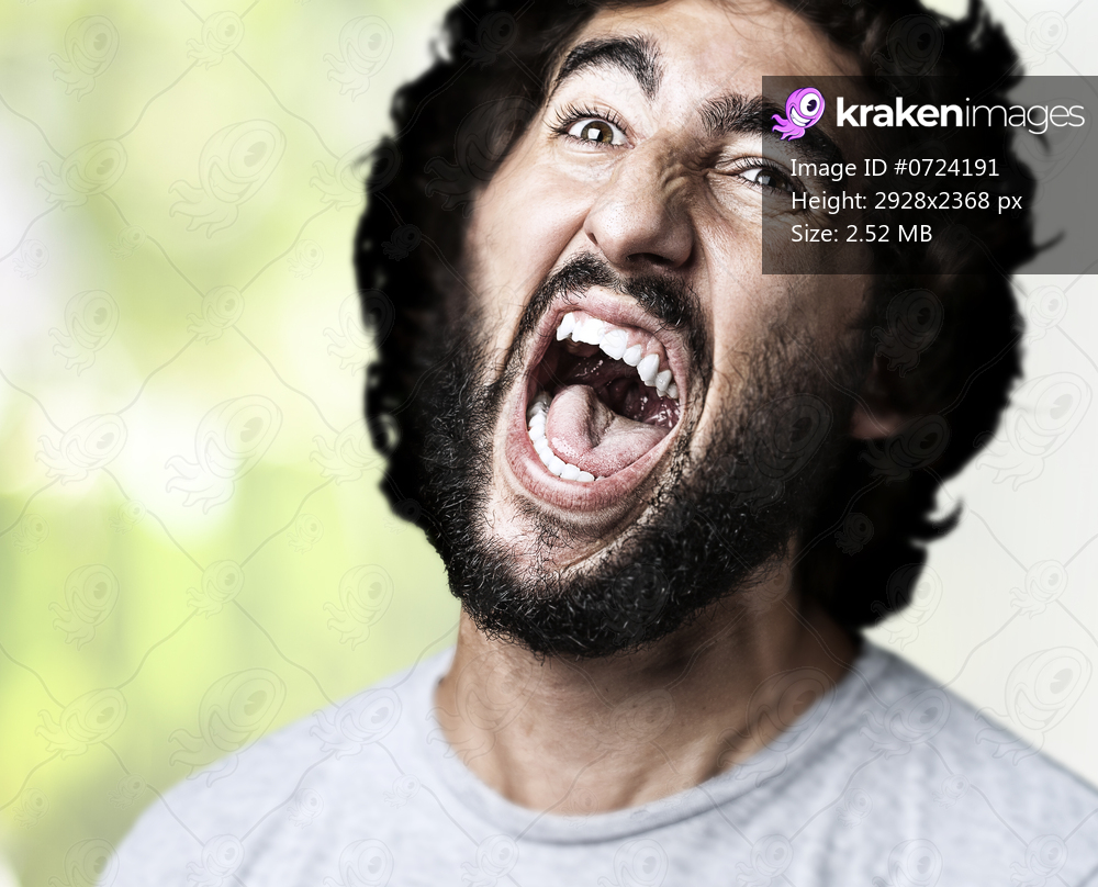 portrait of young man shouting against a nature background