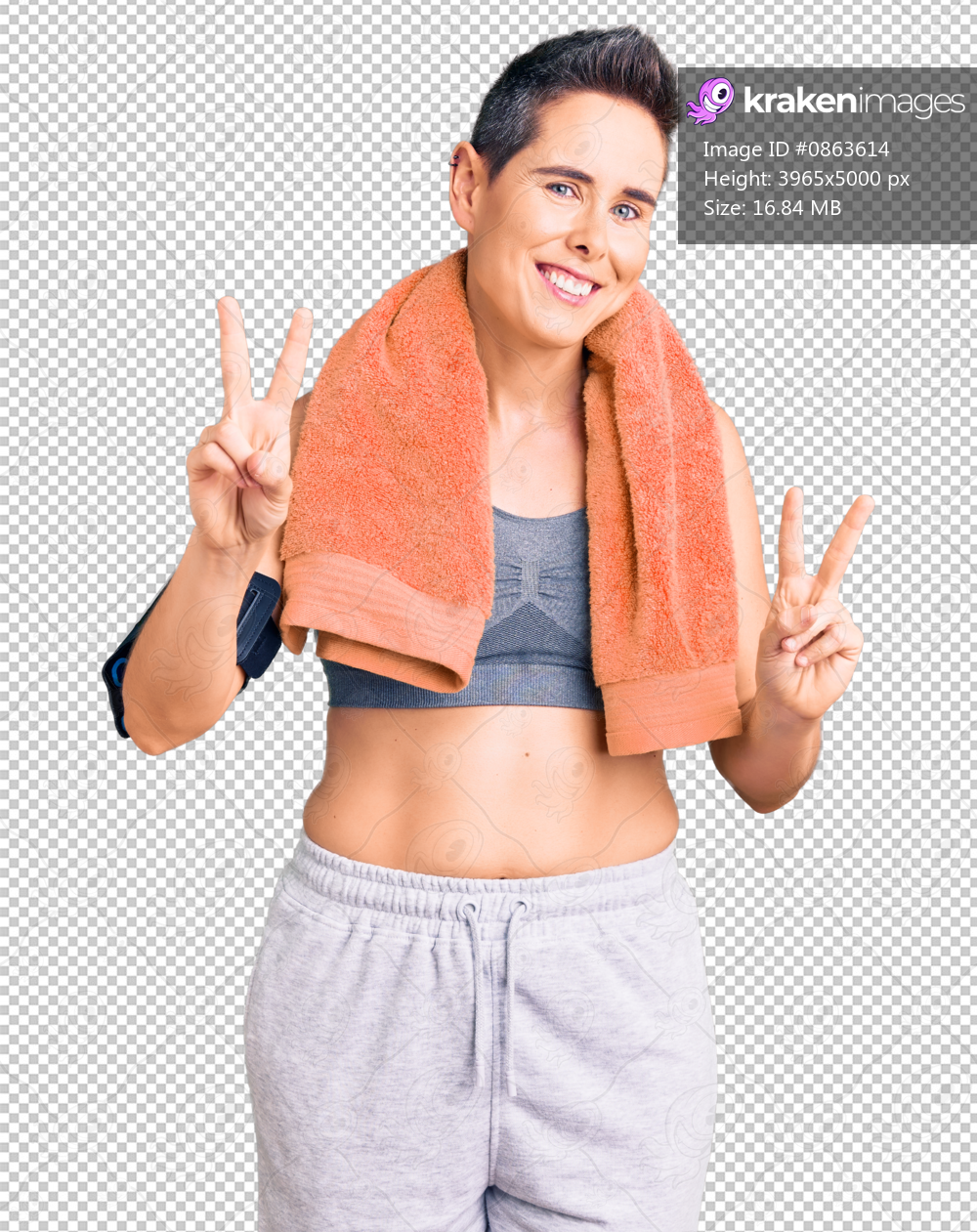 Young woman with short hair wearing sportswear and towel using smartphone smiling looking to the camera showing fingers doing victory sign. number two.
