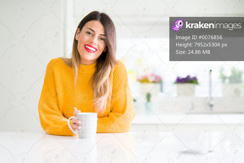 Young beautiful woman drinking a cup of coffee at home with a happy face standing and smiling with a confident smile showing teeth
