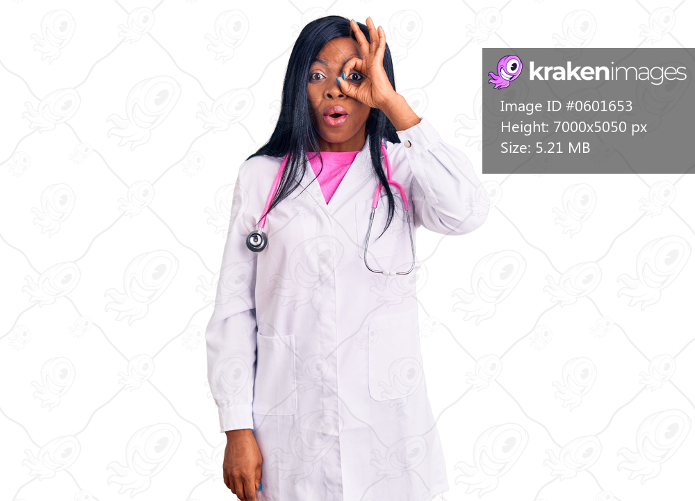 Young african american woman wearing doctor stethoscope doing ok gesture shocked with surprised face, eye looking through fingers. unbelieving expression. 