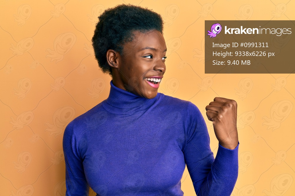 Young african american girl wearing casual clothes pointing thumb up to the side smiling happy with open mouth 