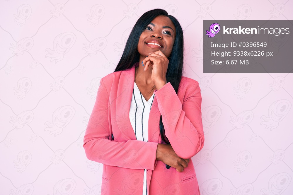 Young african american woman wearing business clothes looking confident at the camera with smile with crossed arms and hand raised on chin. thinking positive. 
