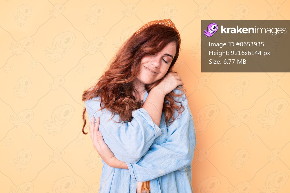 Young beautiful woman wearing casual clothes hugging oneself happy and positive, smiling confident. self love and self care 