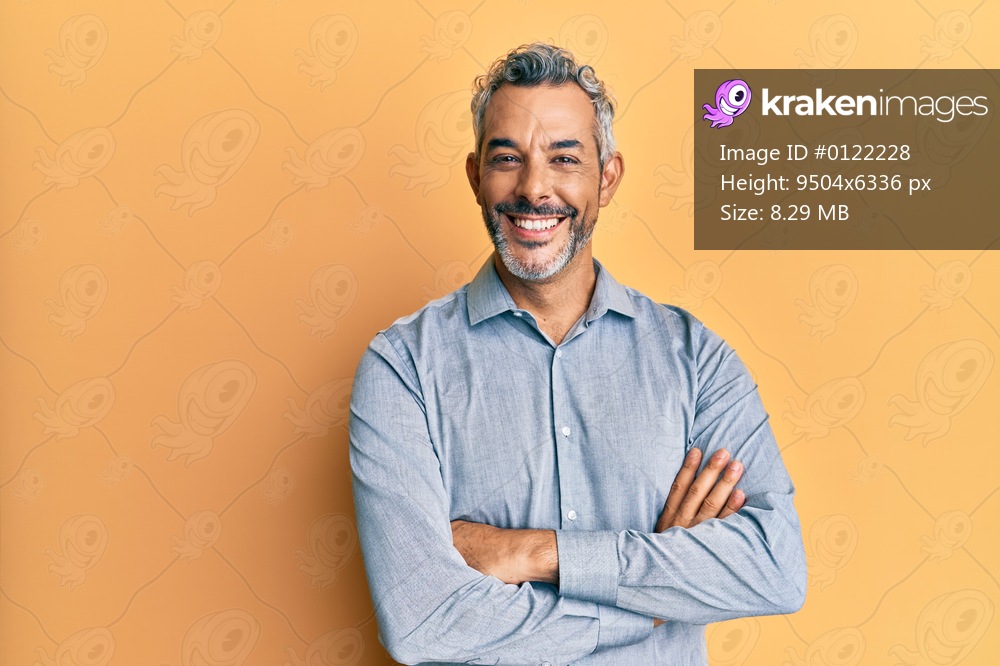 Middle age grey-haired man wearing casual clothes happy face smiling with crossed arms looking at the camera. positive person. 