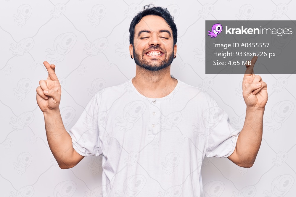 Young hispanic man wearing casual clothes gesturing finger crossed smiling with hope and eyes closed. luck and superstitious concept. 