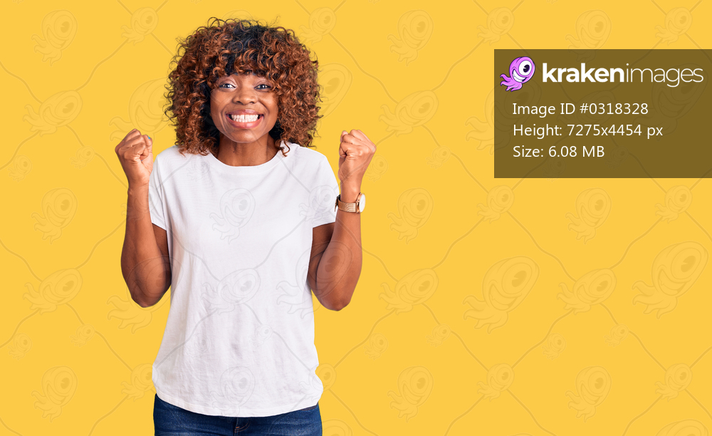 Young african american woman wearing casual white tshirt celebrating surprised and amazed for success with arms raised and open eyes. winner concept. 