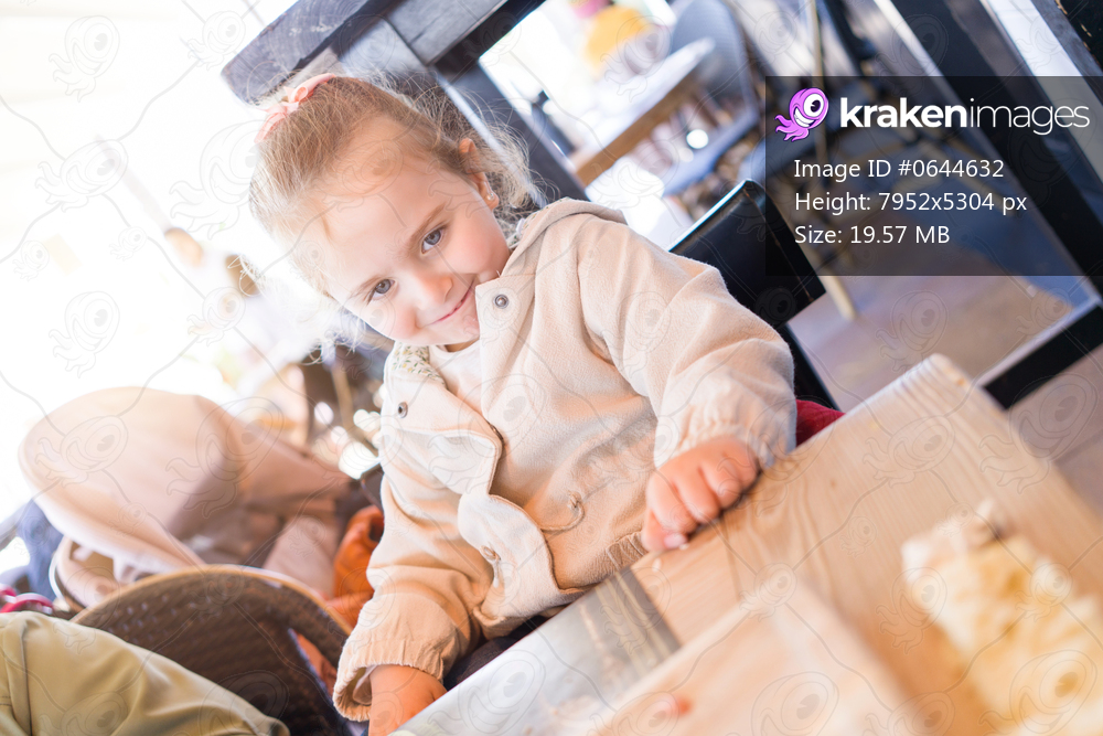 Beautiful toddler child girl sitting on baby highchair laughing