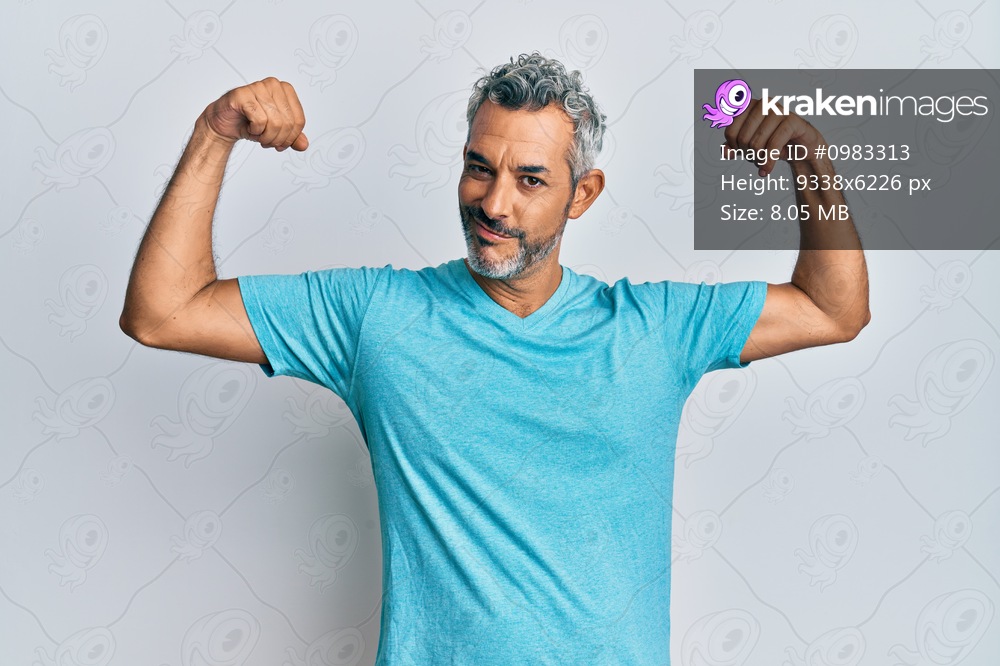 Middle age grey-haired man wearing casual clothes showing arms muscles smiling proud. fitness concept. 