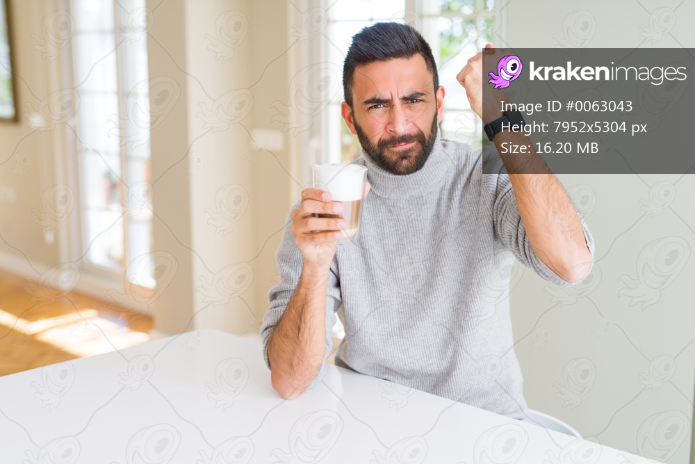 Handsome hispanic man drinking a cup of coffee annoyed and frustrated shouting with anger, crazy and yelling with raised hand, anger concept