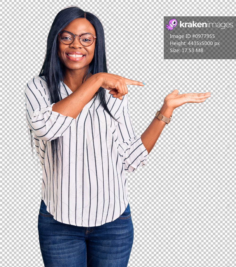 Young african american woman wearing casual clothes and glasses amazed and smiling to the camera while presenting with hand and pointing with finger.