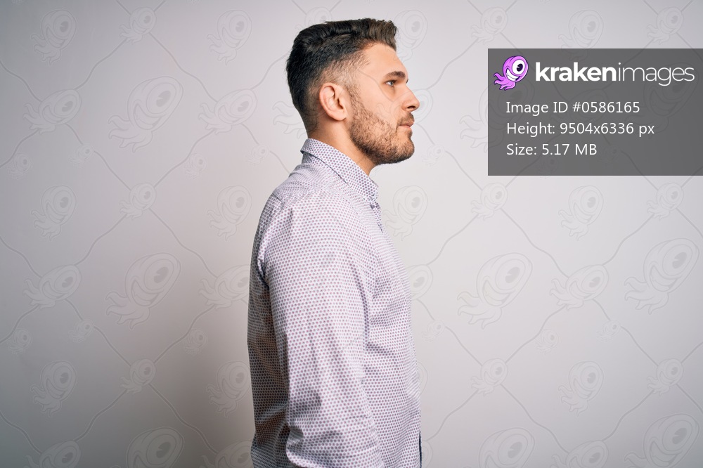 Young business man with blue eyes standing over isolated background looking to side, relax profile pose with natural face with confident smile.