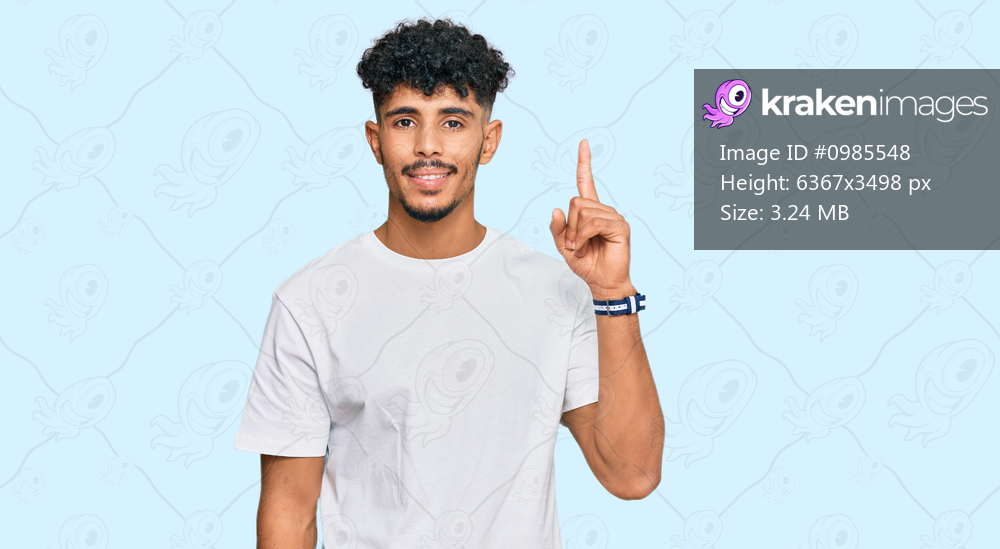 Young arab man wearing casual white t shirt showing and pointing up with finger number one while smiling confident and happy. 