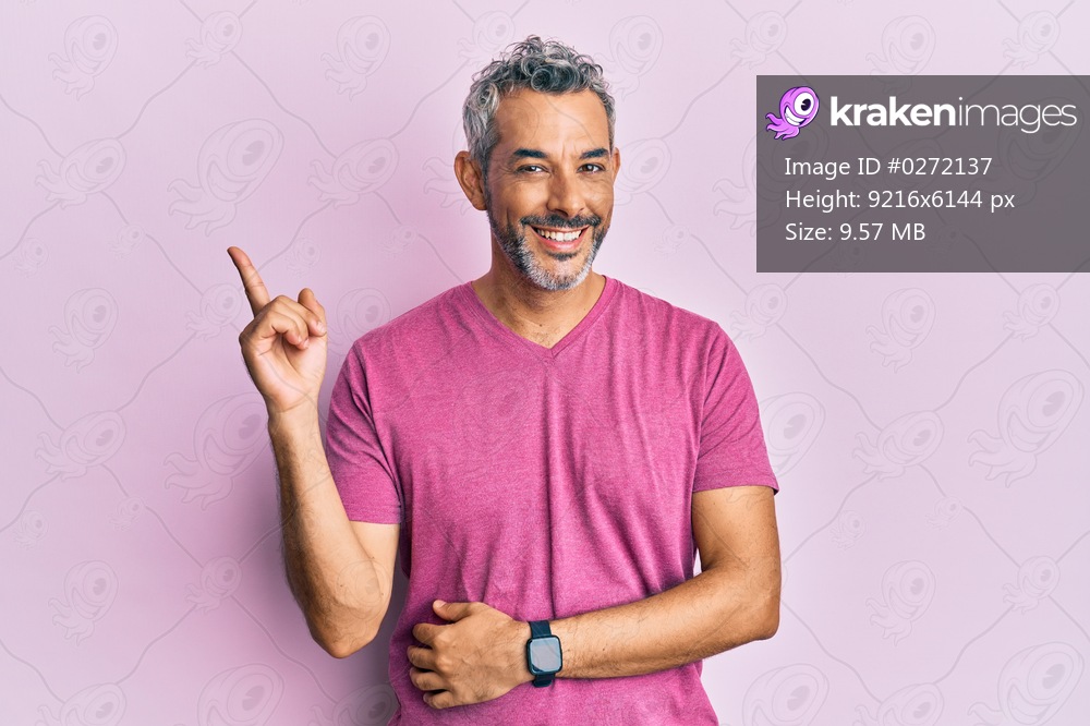 Middle age grey-haired man wearing casual clothes smiling happy pointing with hand and finger to the side 