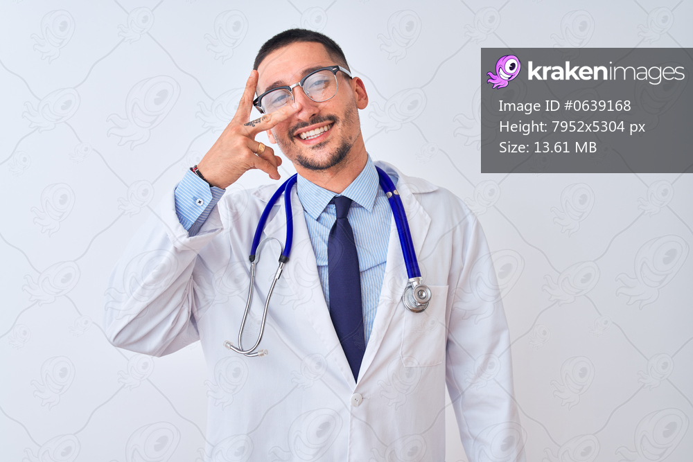 Young doctor man wearing stethoscope over isolated background Doing peace symbol with fingers over face, smiling cheerful showing victory