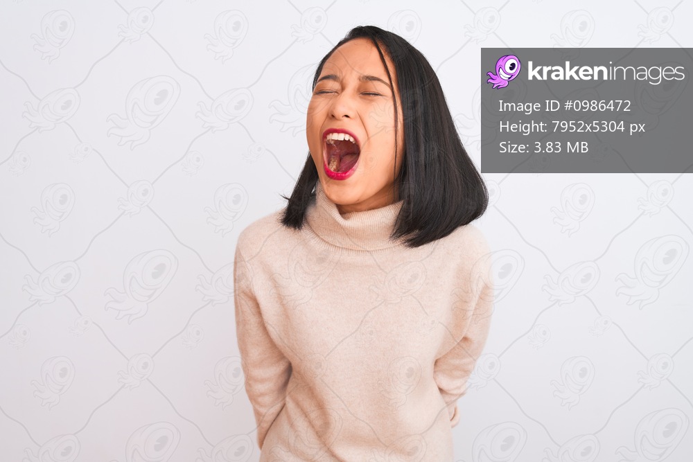 Young chinese woman wearing turtleneck sweater standing over isolated white background angry and mad screaming frustrated and furious, shouting with anger. Rage and aggressive concept.