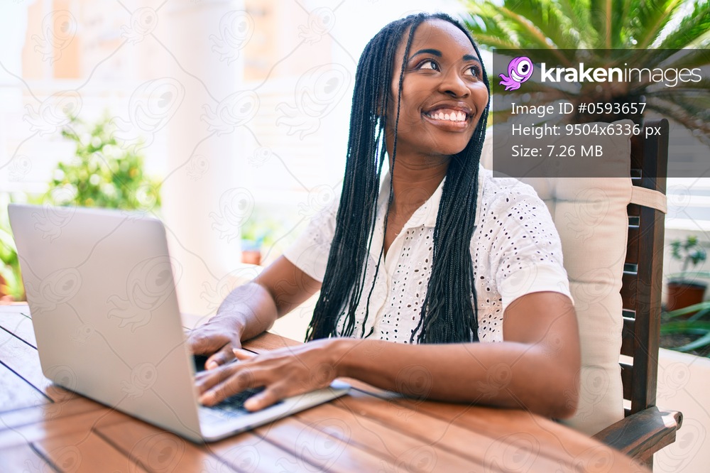 Young african american woman smiling happy working using laptop at terrace