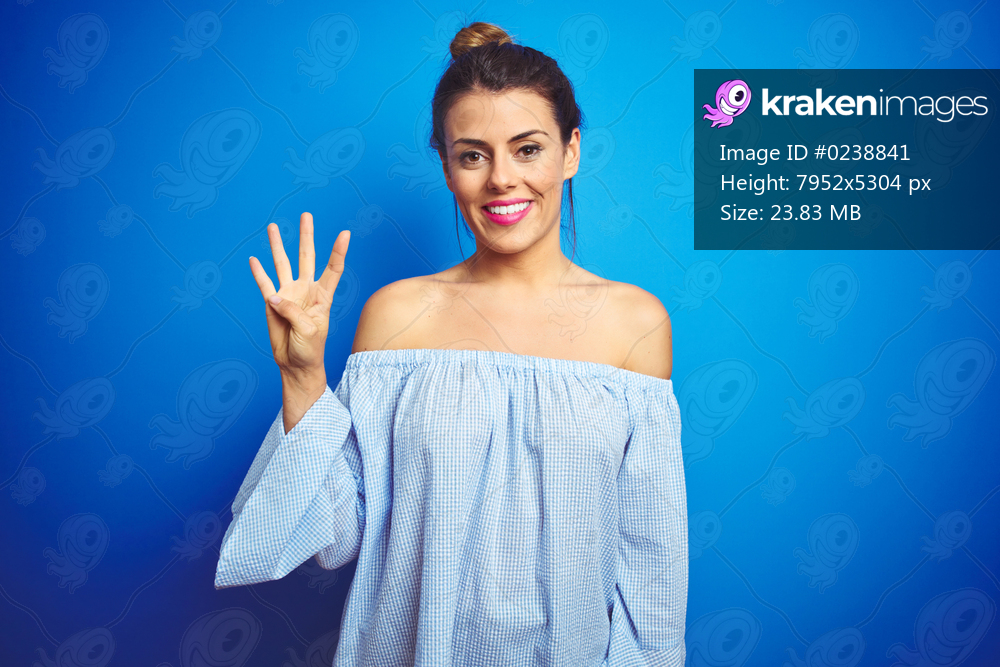 Young beautiful woman wearing bun hairstyle over blue isolated background showing and pointing up with fingers number four while smiling confident and happy.