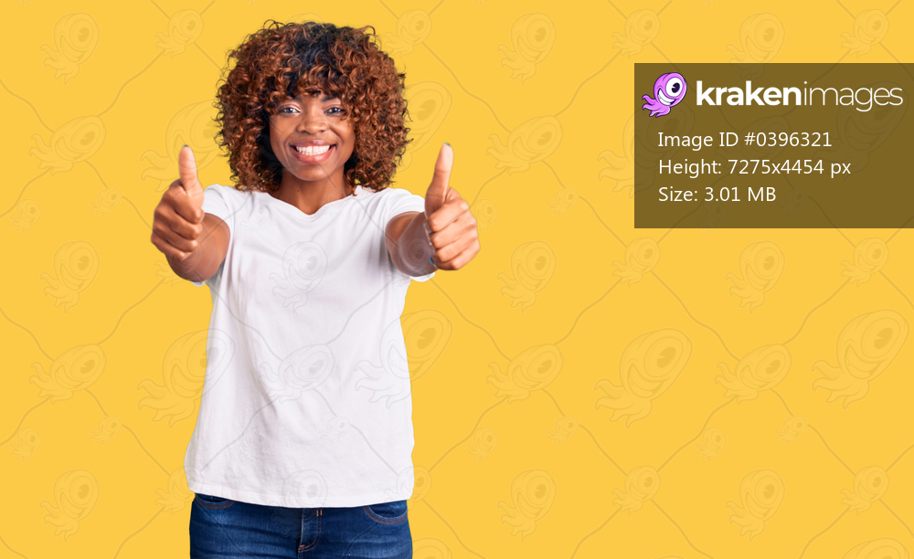 Young african american woman wearing casual white tshirt approving doing positive gesture with hand, thumbs up smiling and happy for success. winner gesture. 