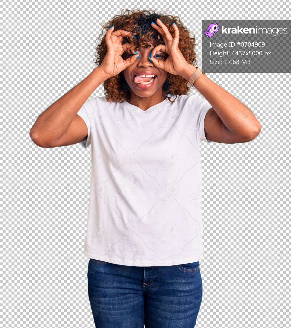 Young african american woman wearing casual white tshirt doing ok gesture like binoculars sticking tongue out, eyes looking through fingers. crazy expression.