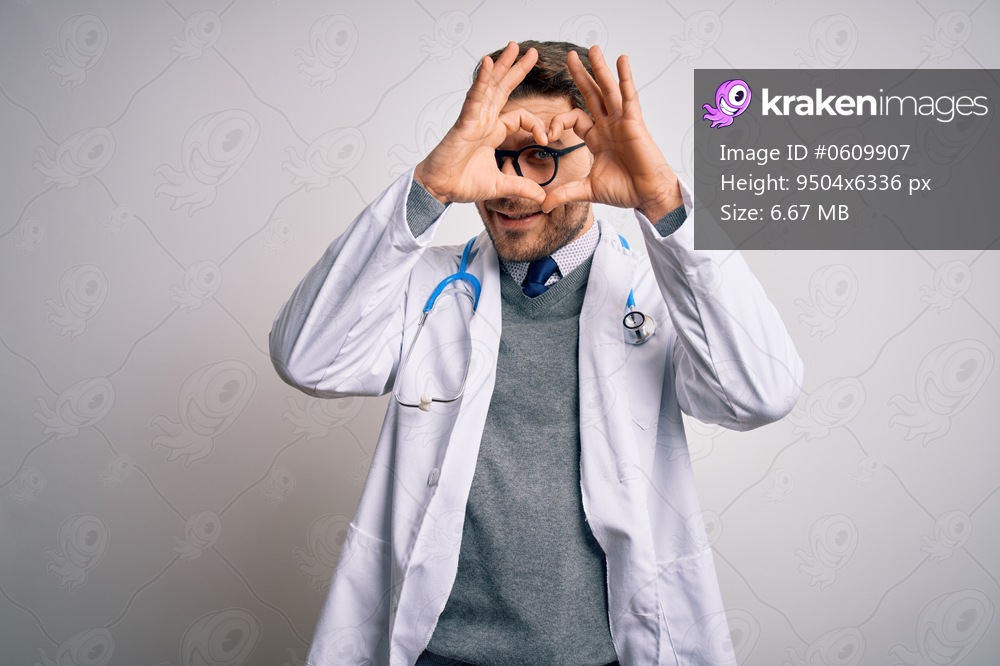 Young doctor man with blue eyes wearing medical coat and stethoscope over isolated background Doing heart shape with hand and fingers smiling looking through sign
