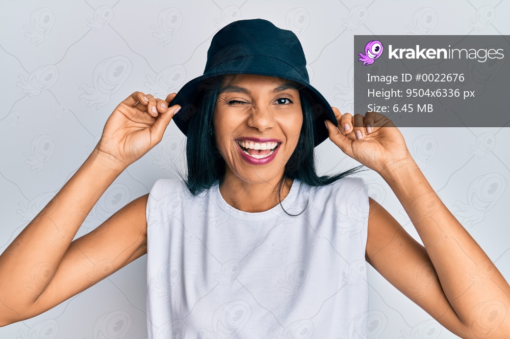 Young african american woman wearing fashion hat winking looking at the camera with sexy expression, cheerful and happy face. 
