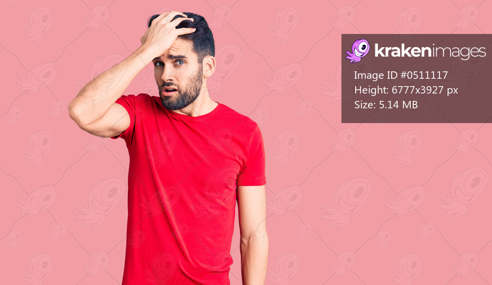 Young handsome man with beard wearing casual t-shirt surprised with hand on head for mistake, remember error. forgot, bad memory concept. 