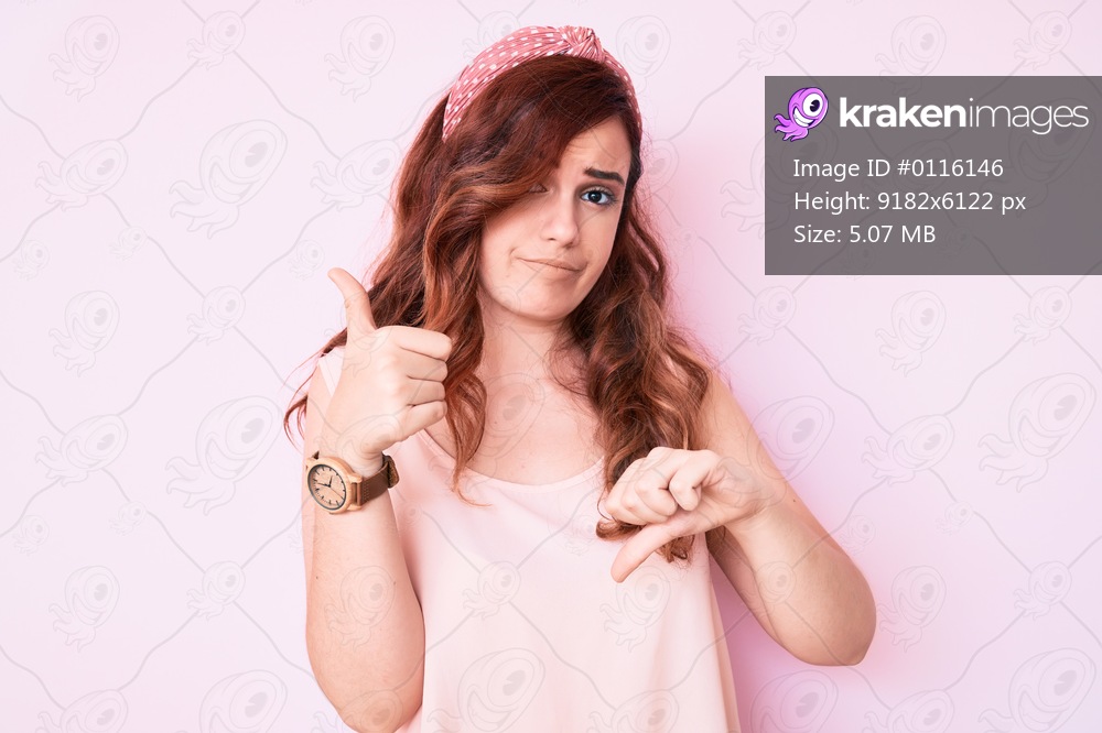 Young beautiful woman wearing casual clothes doing thumbs up and down, disagreement and agreement expression. crazy conflict 