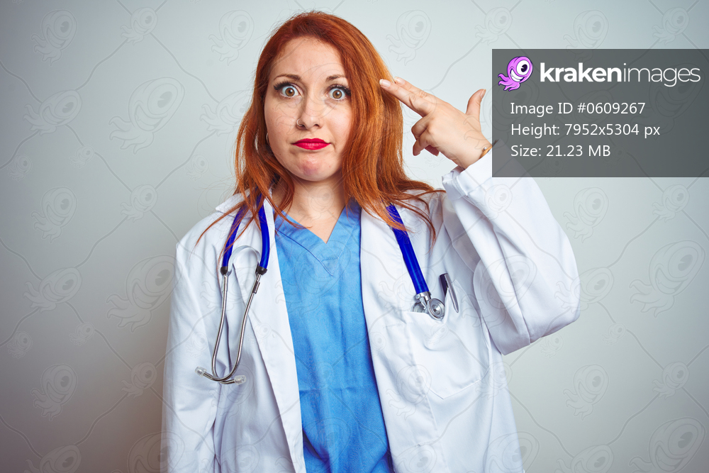 Young redhead doctor woman using stethoscope over white isolated background Shooting and killing oneself pointing hand and fingers to head like gun, suicide gesture.