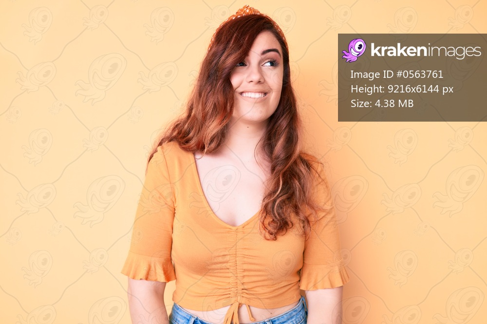 Young beautiful woman wearing casual clothes looking away to side with smile on face, natural expression. laughing confident. 