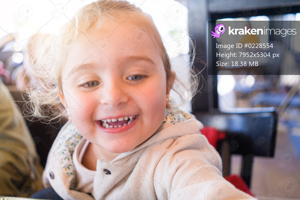 Beautiful toddler child girl sitting on baby highchair laughing