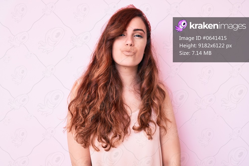 Young beautiful woman wearing casual clothes looking at the camera blowing a kiss on air being lovely and sexy. love expression. 